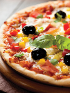 Hot pizza with fresh olives, peppers, and herbs