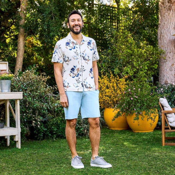 Man in flowered shirt and blue shorts